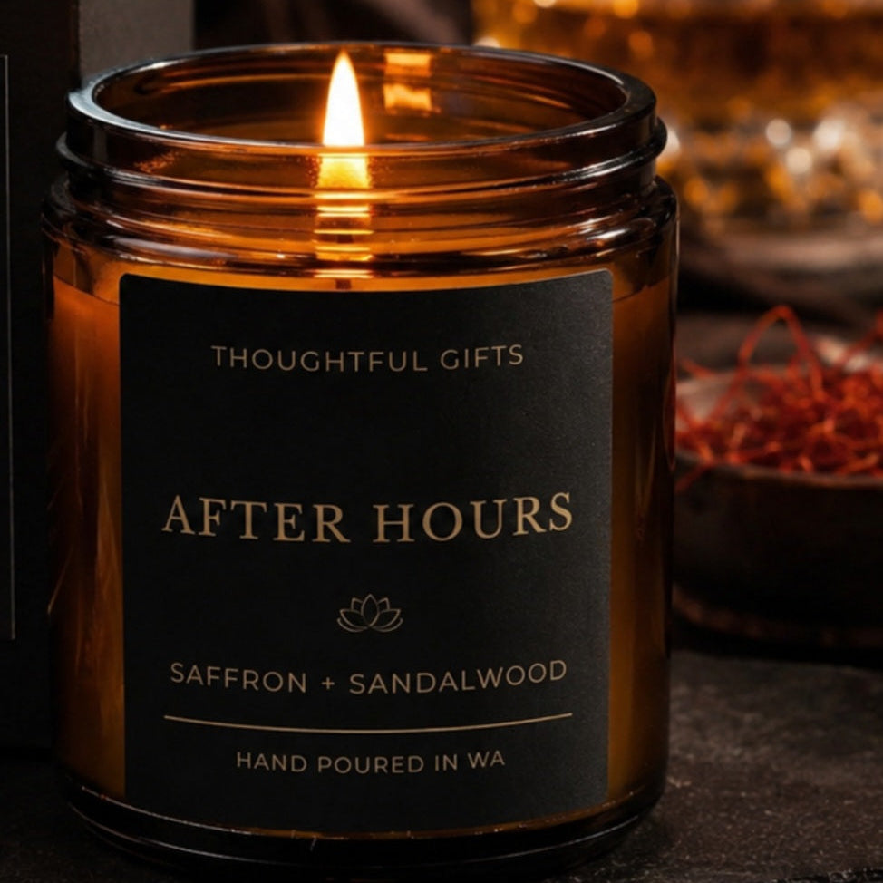 Candle labeled 'After Hours' with saffron and sandalwood fragrance, surrounded by a glass of whiskey and gift box.
